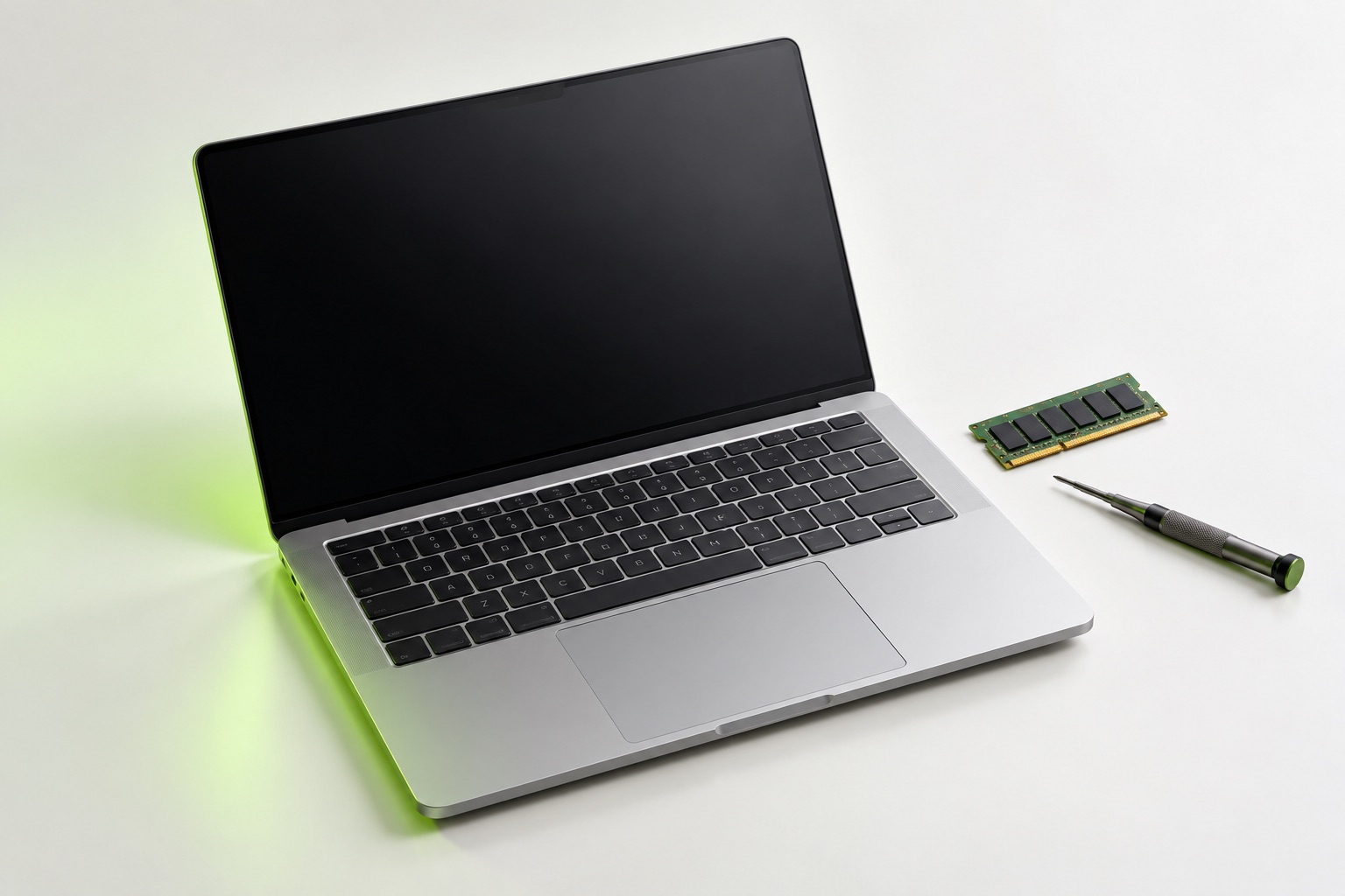 Illustrative studio study of an unbranded laptop, memory module and precision screwdriver